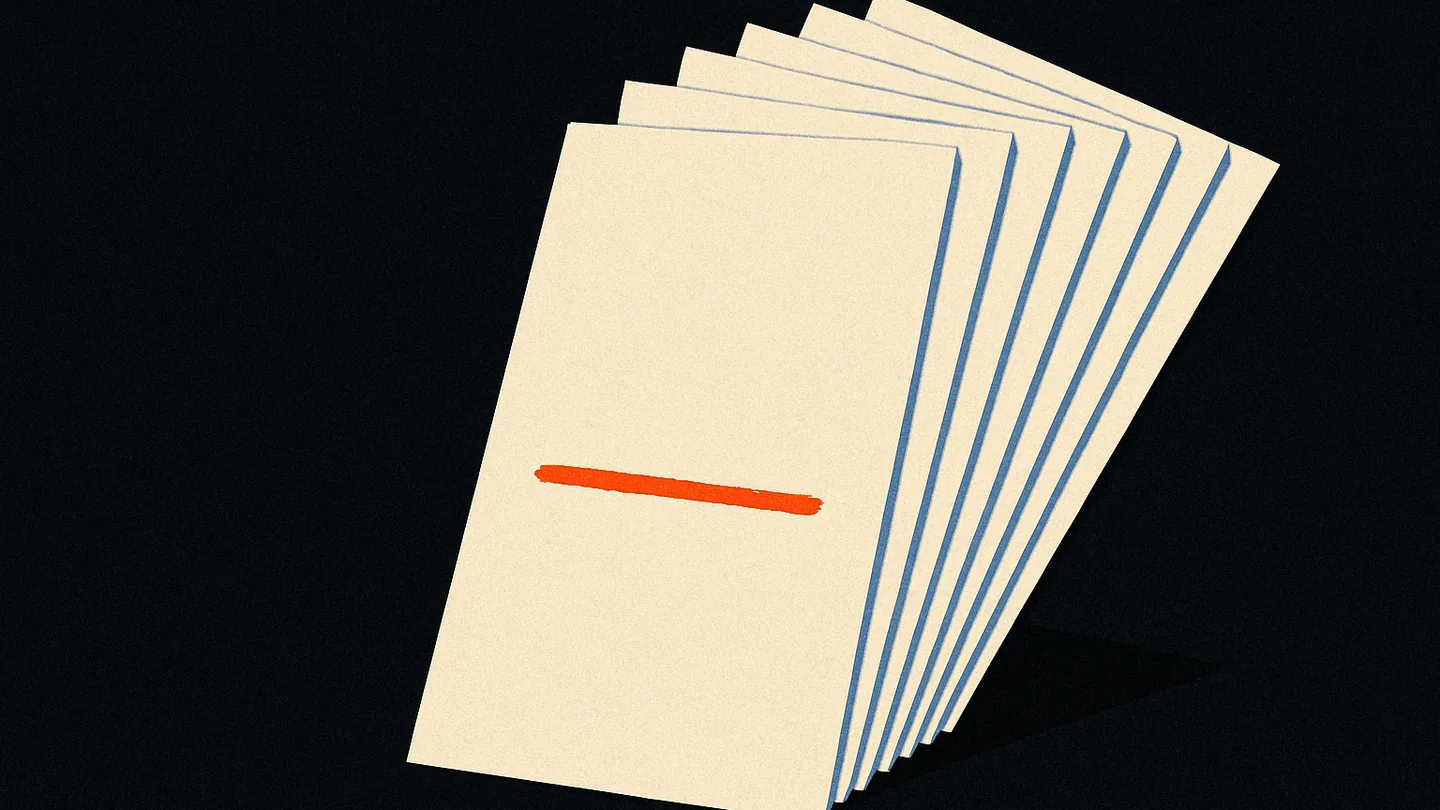 A fanned stack of seven index cards on a dark surface, one card marked with a single glowing orange line.