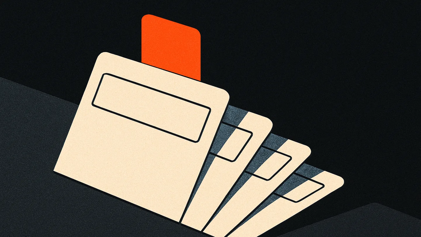 A small tray holding a phone, a notebook, and a pen on a dark desk, one orange tab standing up from the notebook.