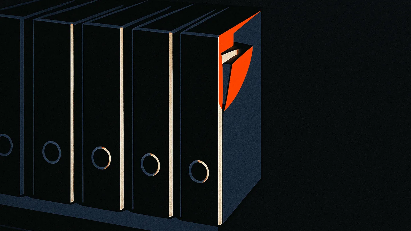 A row of black ring-binders on a dark shelf, one tab pulled open slightly further than the rest and glowing orange.
